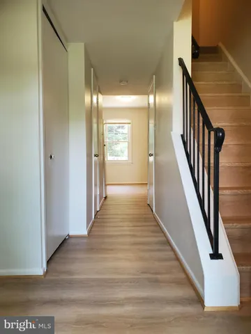 a view of a hallway with wooden floor and staircase