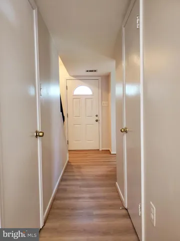 a view of a hallway with wooden floor
