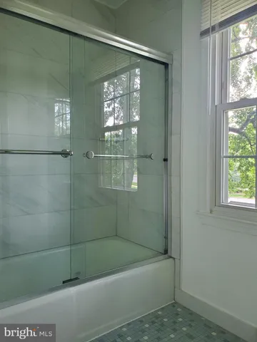 a bathroom with a shower and window