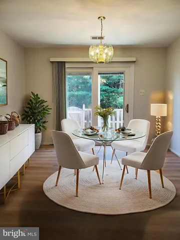 a view of a dining room with furniture a chandelier and wooden floor