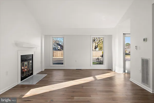 a view of an empty room with window and fireplace