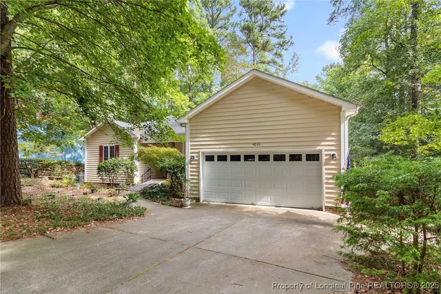 a view of a house with a yard and large tree