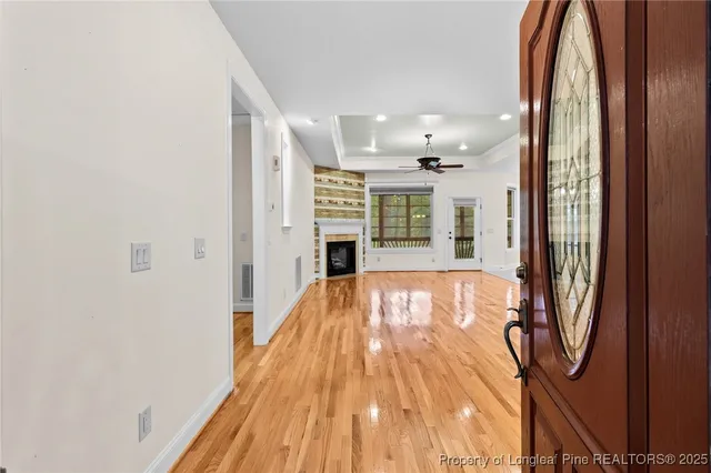 a view of a livingroom with wooden floor and a ceiling fan