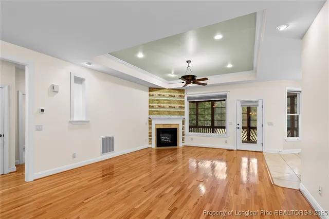 a view of a big room with wooden floor fireplace and windows
