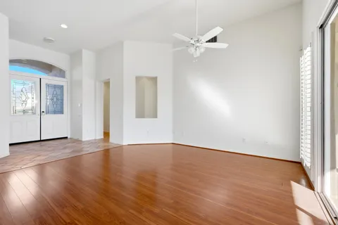 an empty room with wooden floor and natural light