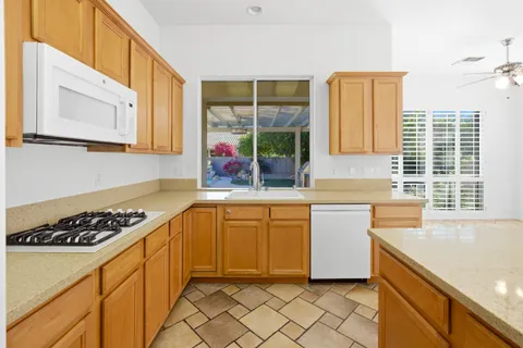 a large white kitchen with a large window cabinets and stainless steel appliances