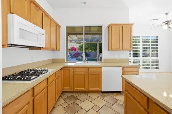 a large white kitchen with a large window cabinets and stainless steel appliances