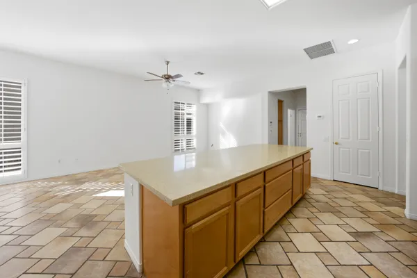a view of an empty room with a window and a ceiling fan