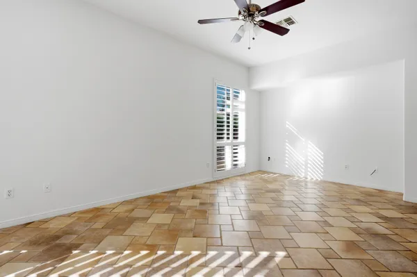 a view of an empty room with a window and a ceiling fan