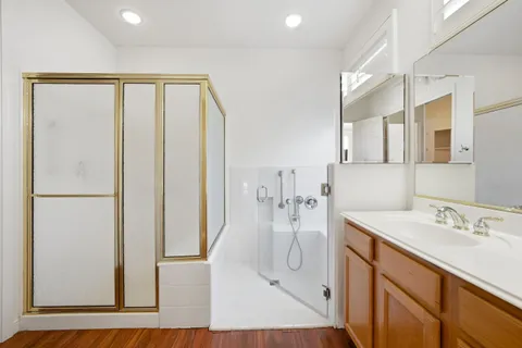 an empty room with wooden floor and fan