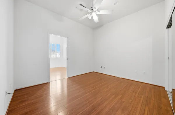 an empty room with wooden floor and windows