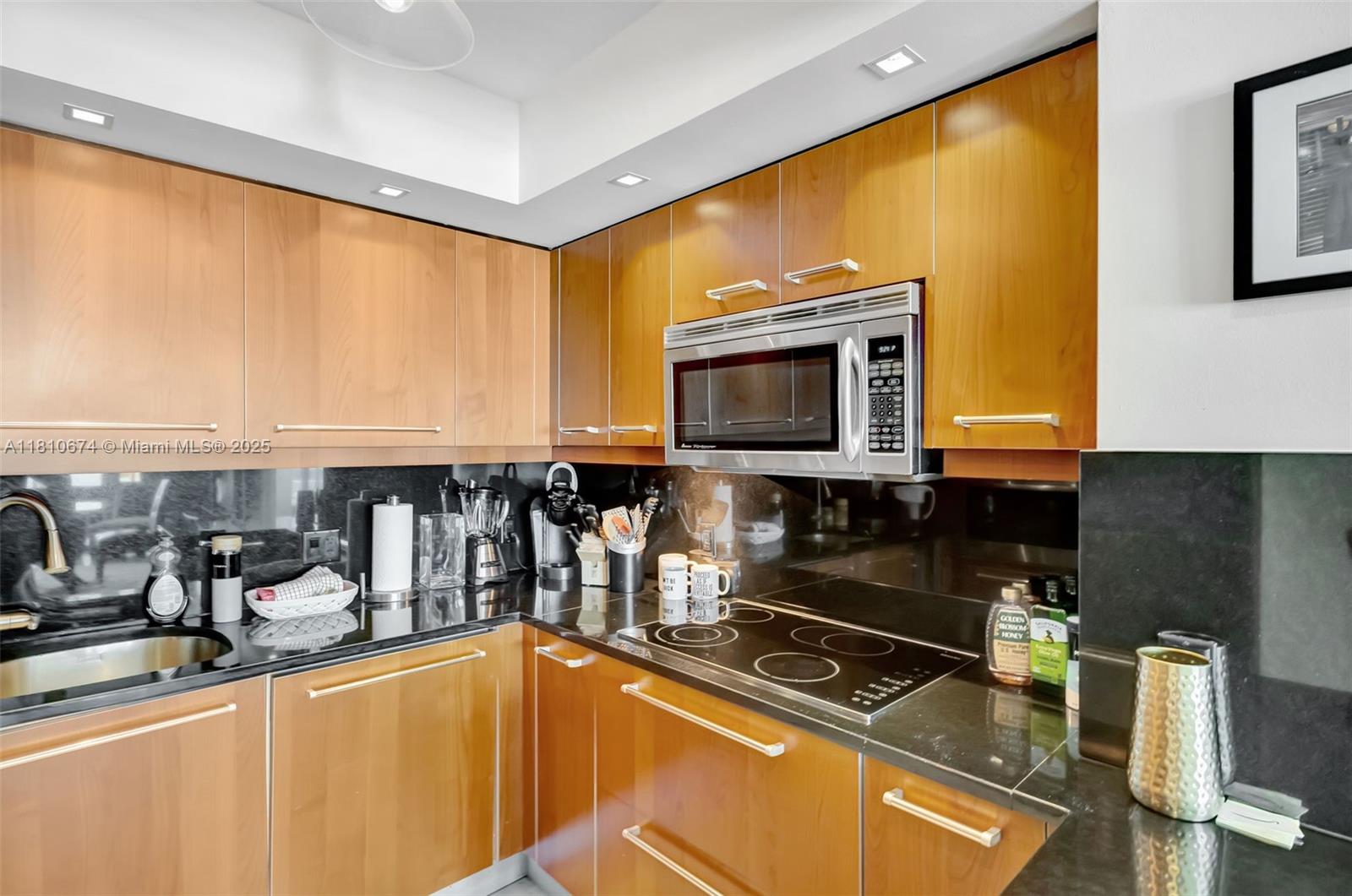 1331 Brickell Bay Drive, Unit 1504 Miami, FL 33131 - Photo 4 of 30 a kitchen with stainless steel appliances a sink counter space and a window