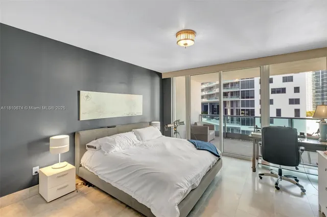 a bedroom with a bed and large windows