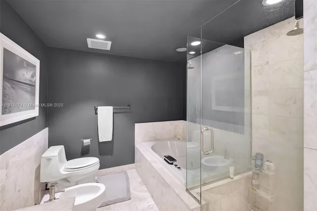 a bathroom with a tub toilet and shower