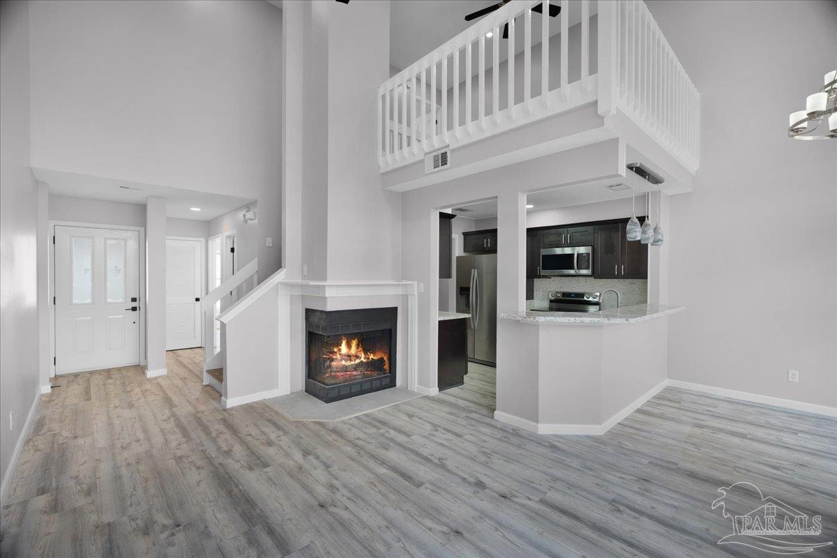 601 East Burgess Road, Unit J2 Pensacola, FL 32504 - Photo 13 of 38 a view of an empty room with wooden floor fireplace and a window