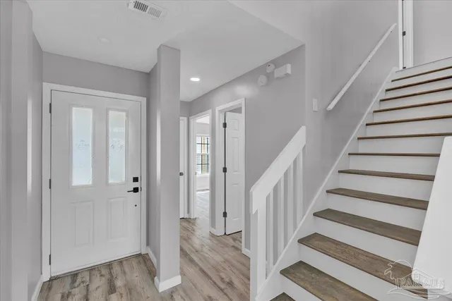 a view of entryway with wooden floor and stairs