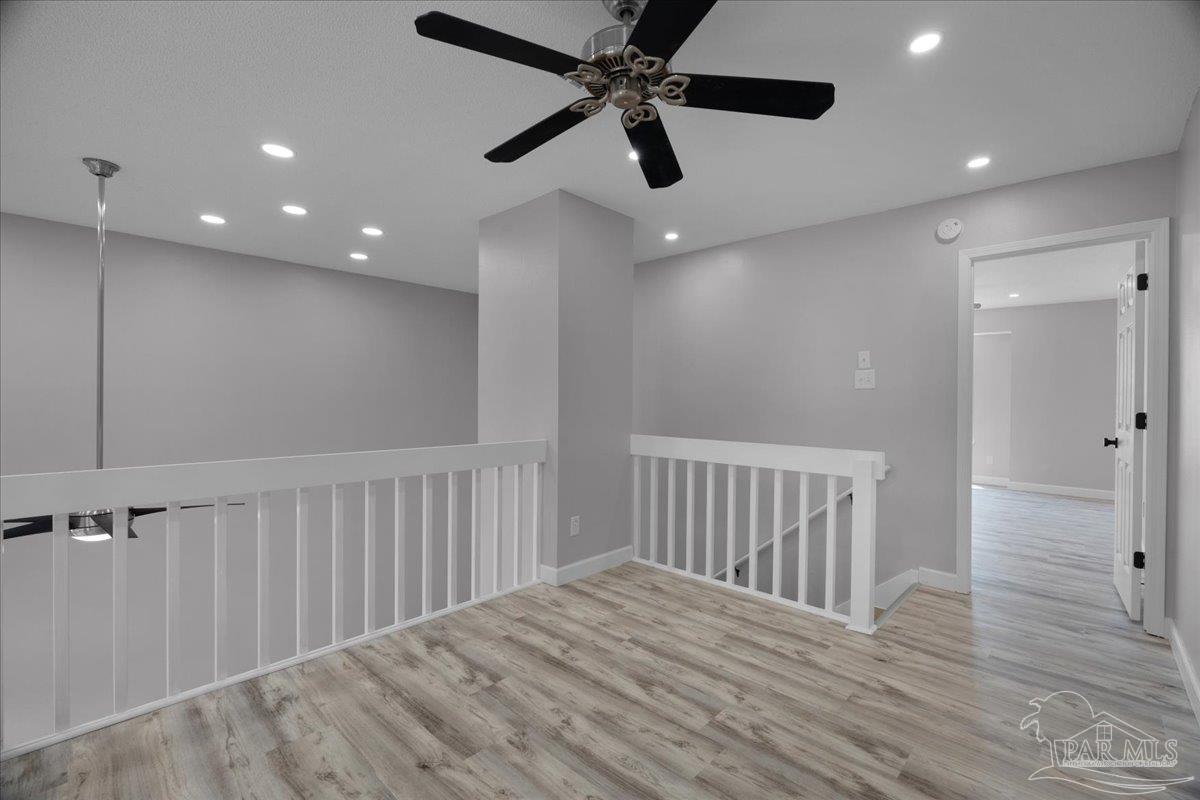 601 East Burgess Road, Unit J2 Pensacola, FL 32504 - Photo 20 of 38 an empty room with wooden floor fan and windows