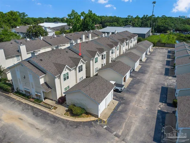 an aerial view of residential houses with outdoor space and parking