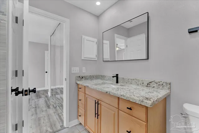 a bathroom with a granite countertop sink vanity and mirror