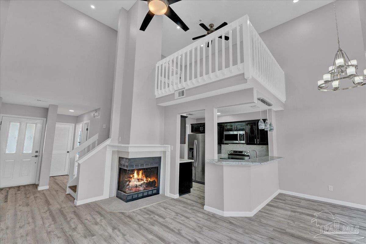 601 East Burgess Road, Unit J2 Pensacola, FL 32504 - Photo 27 of 38 a view of an empty room with wooden floor and a kitchen