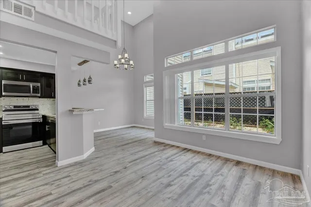 a view of a kitchen with wooden floor and electronic appliances