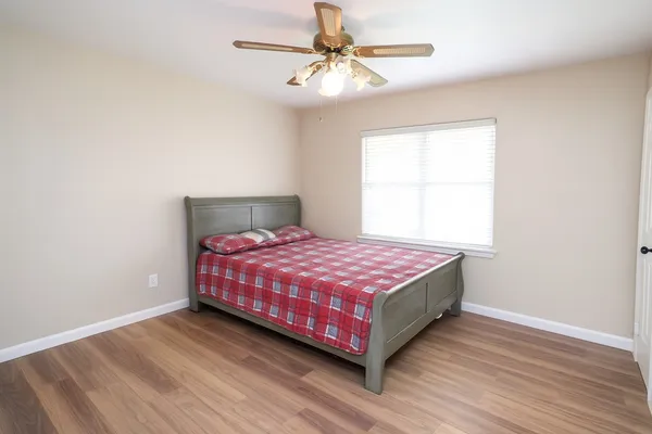 a bedroom with a bed chandelier and a window