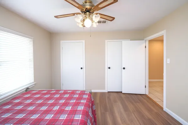 a view of a bedroom with a bed and a chandelier fan