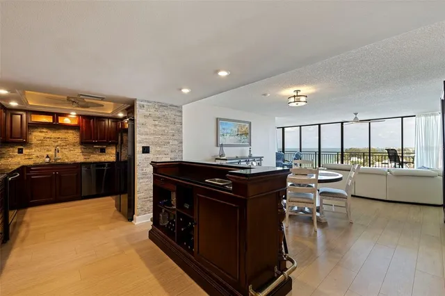 a living room with furniture a large window and kitchen view