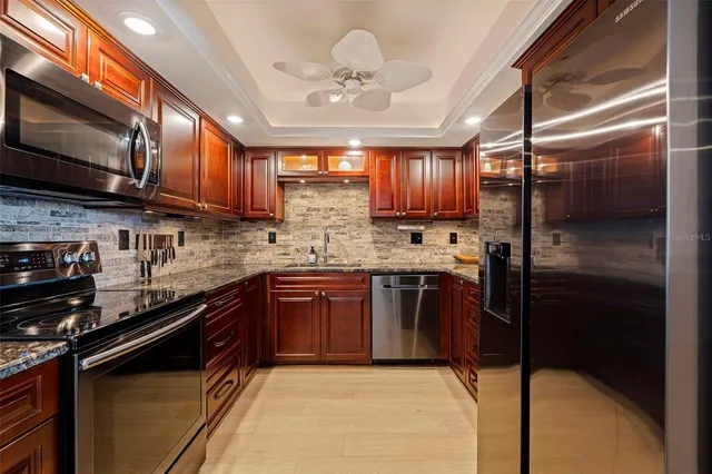 a kitchen with stainless steel appliances granite countertop wooden cabinets a stove top oven a sink and dishwasher