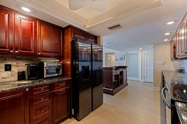 a kitchen with granite countertop wooden cabinets and a stove top oven