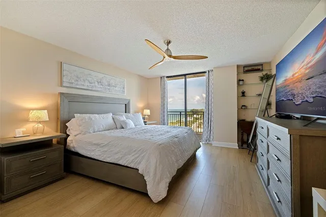 a bedroom with a large bed and a flat tv screen on dresser