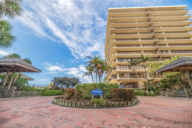 a view of a multi story residential apartment building with a yard