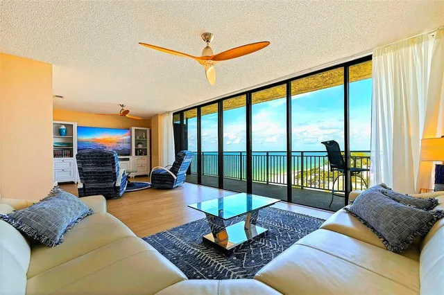 a living room with couch floor to ceiling window and a flat screen tv