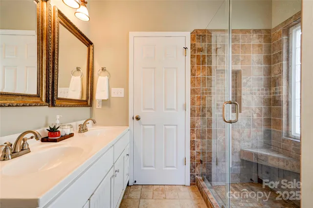 a bathroom with a double vanity sink and shower
