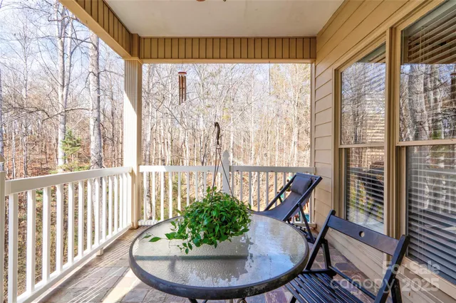 a view of a balcony with chairs and wooden floor