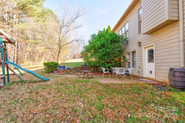 a view of house with backyard and sitting area