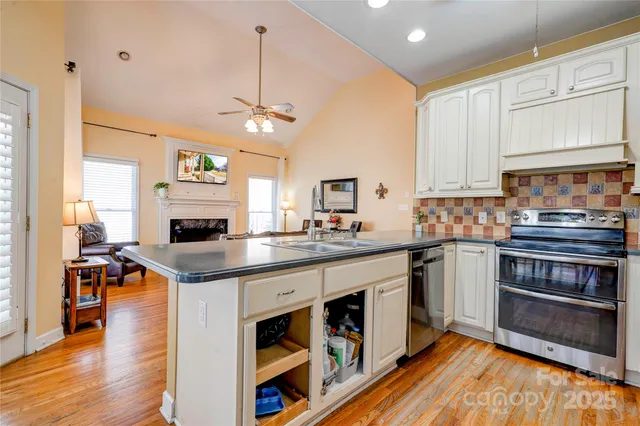 a kitchen with stainless steel appliances granite countertop a stove and cabinets