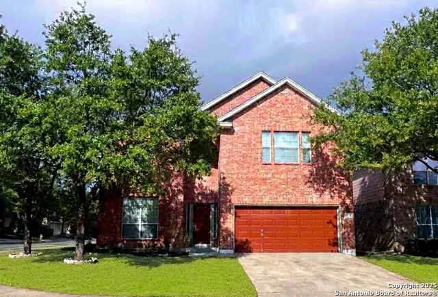 front view of house with a yard and trees