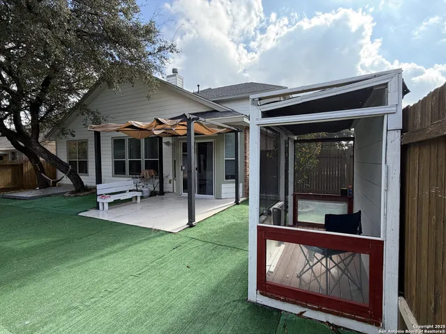 a view of a patio with a table and chairs under a large tree