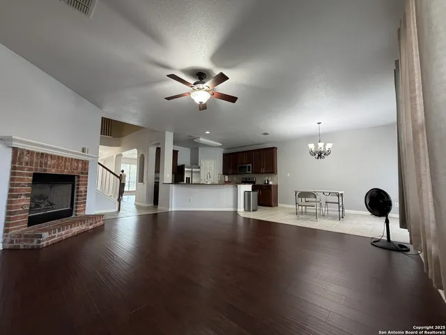 a view of an empty room with a fireplace and wooden floor