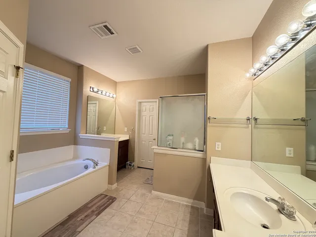 a bathroom with a tub sink and mirror