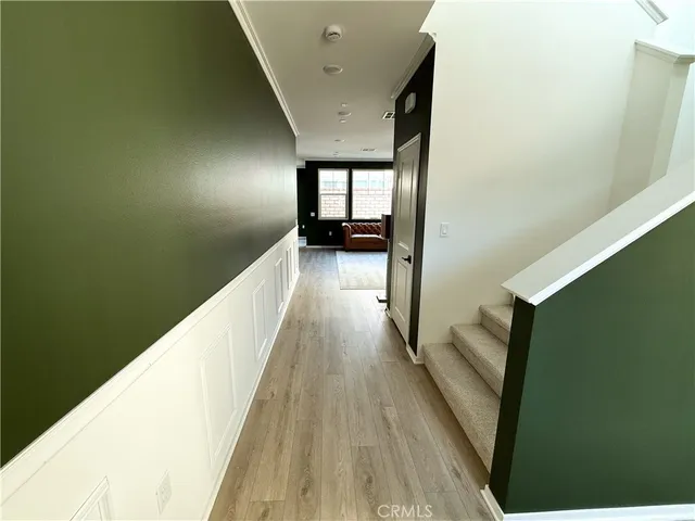a view of a hallway with wooden floor and staircase