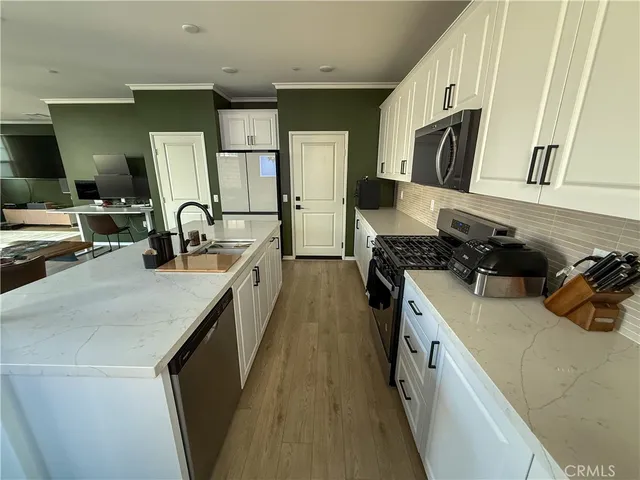 a kitchen with a sink a stove and cabinets