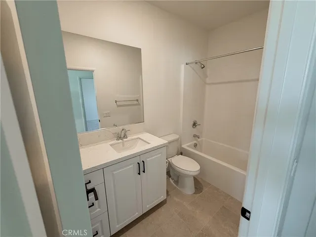 a bathroom with a sink a toilet a mirror a vanity and shower