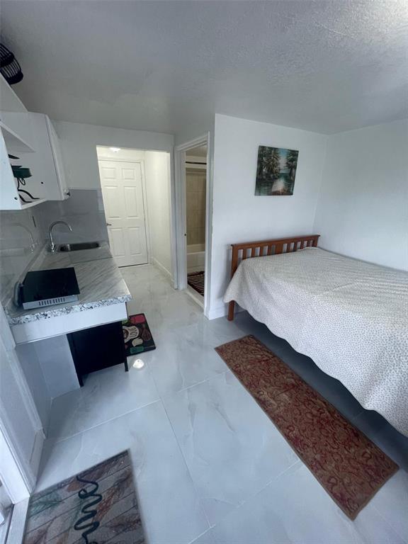 a bedroom with a bed lamp and a couch