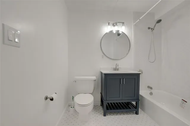 a bathroom with a toilet a sink a bathtub and vanity
