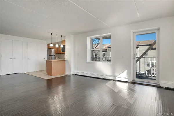 a view of a kitchen with wooden floor and a refrigerator