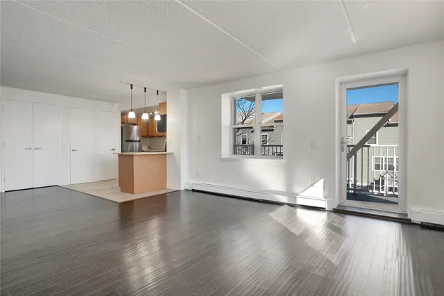 a view of a kitchen with wooden floor and a refrigerator