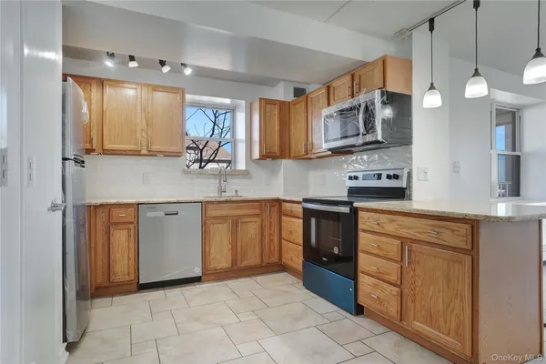 a kitchen with a sink a counter top space cabinets and stainless steel appliances