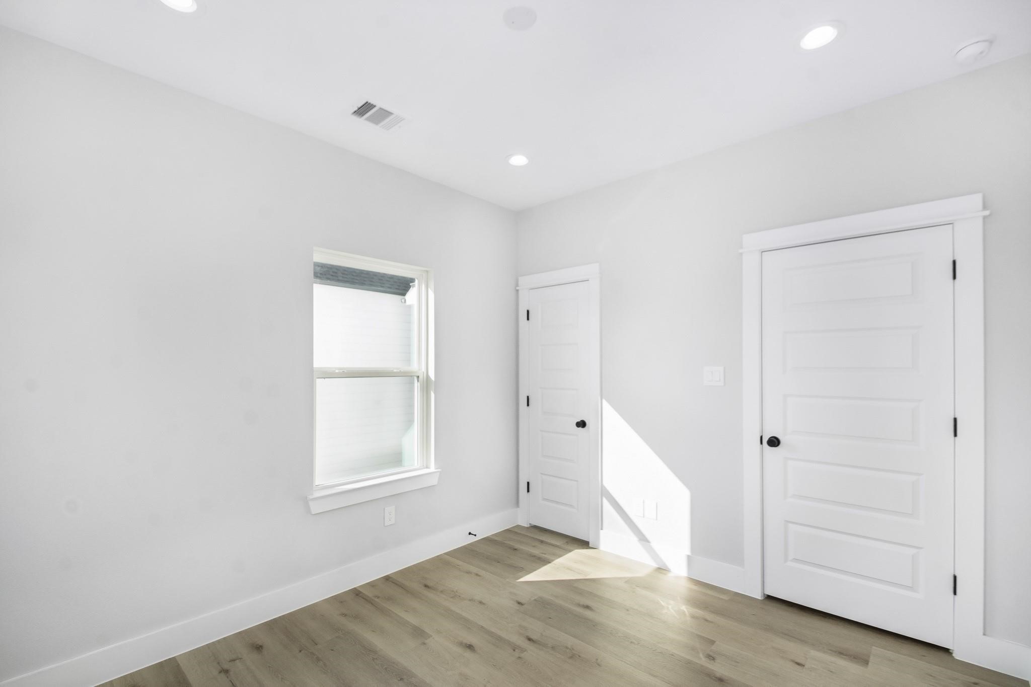 2105 Sam Wilson Street, Unit A Houston, TX 77020 - Photo 13 of 20 an empty room with wooden floor cabinet and windows